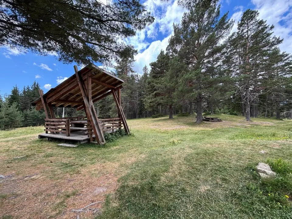 A wooden picnic shelter in the meadow near Semkovo Hut.