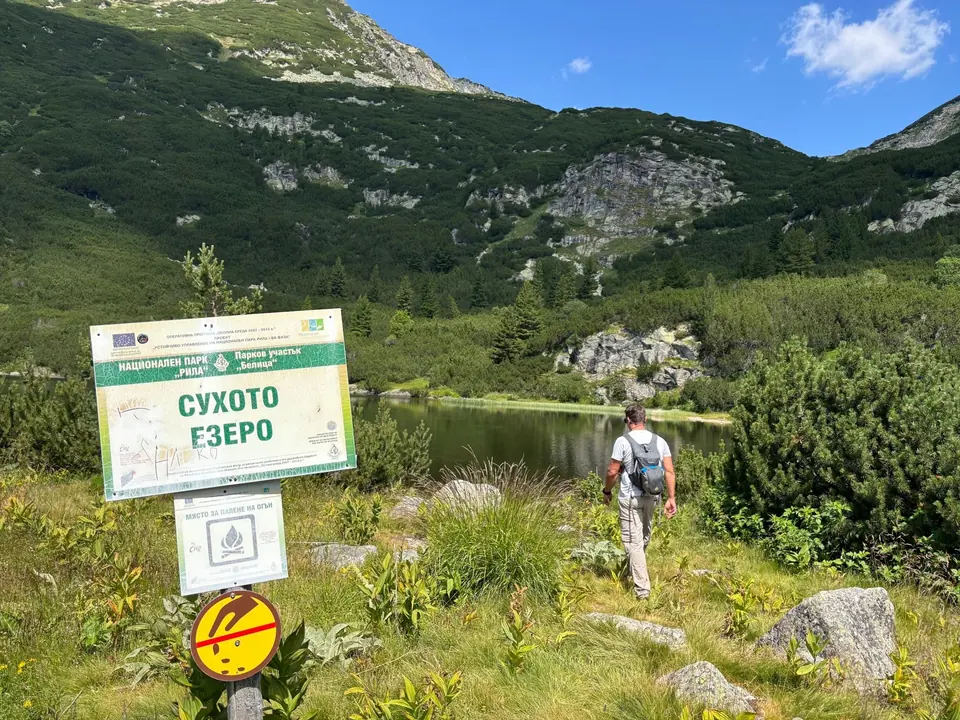 Suhoto Lake sign, lakeshore and mountain bowl.