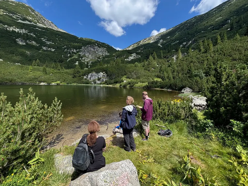 Walkers resting at Suhoto Lake with the mountain bowl beyond.