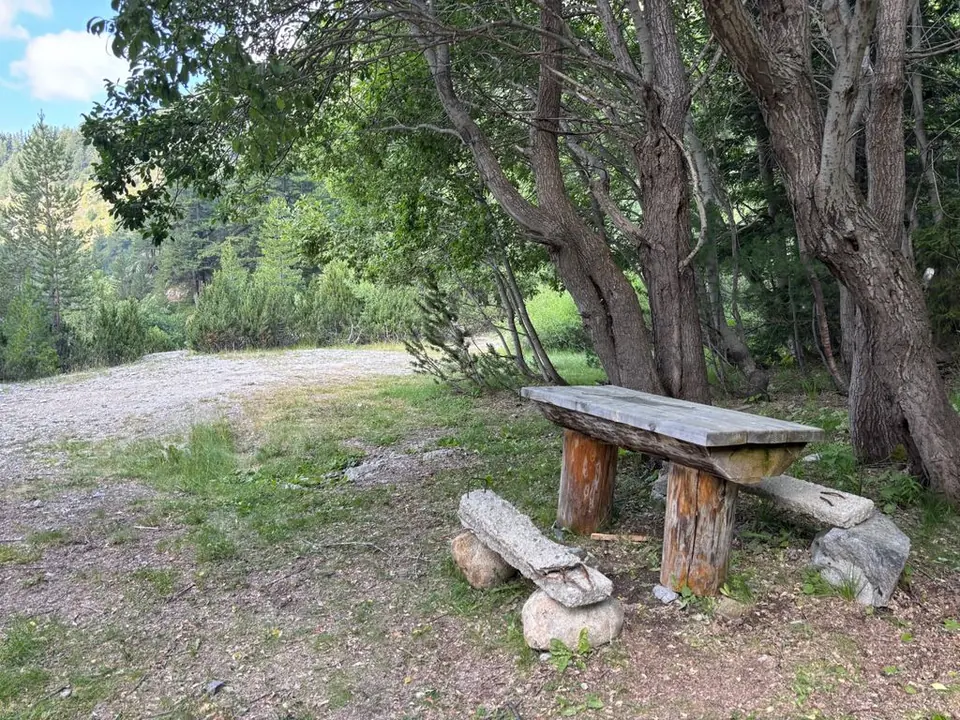 Wooden table and benches in shade along the waterfall route.
