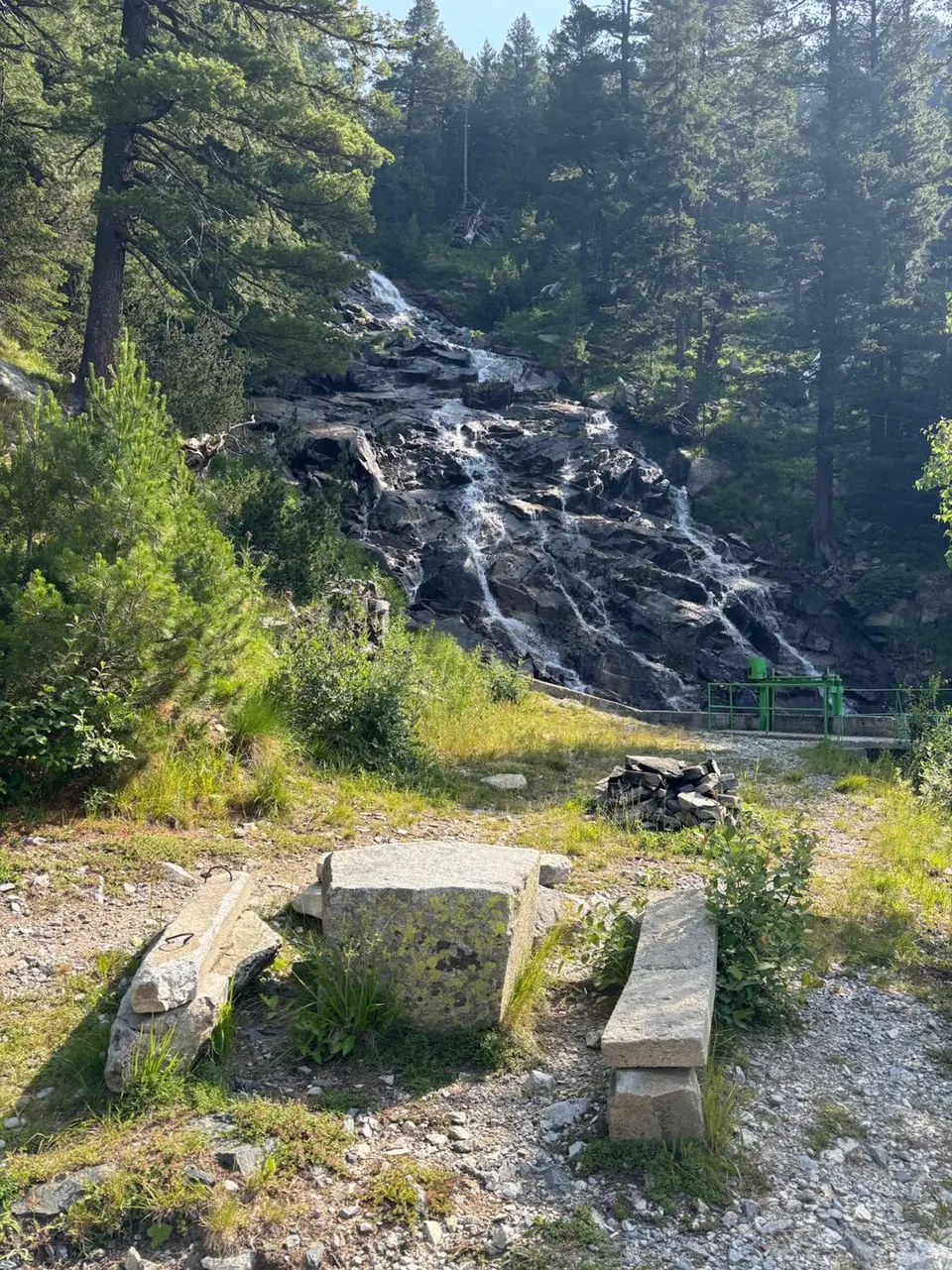 Stone picnic table and benches with Karaalanitsa cascade behind.