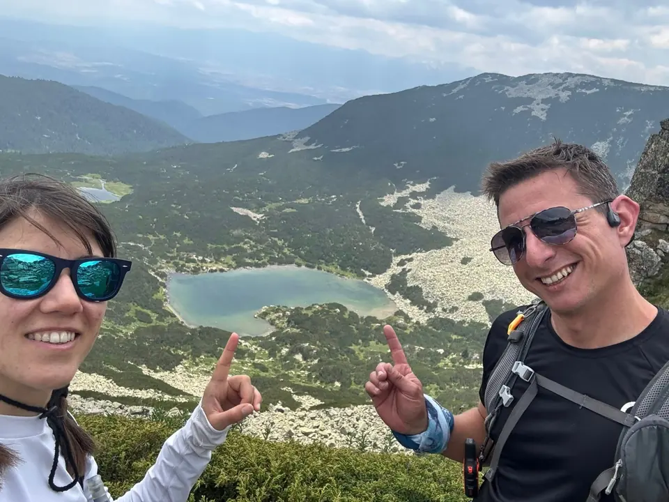 Two walkers overlooking a mountain lake on the Kanarata outing.